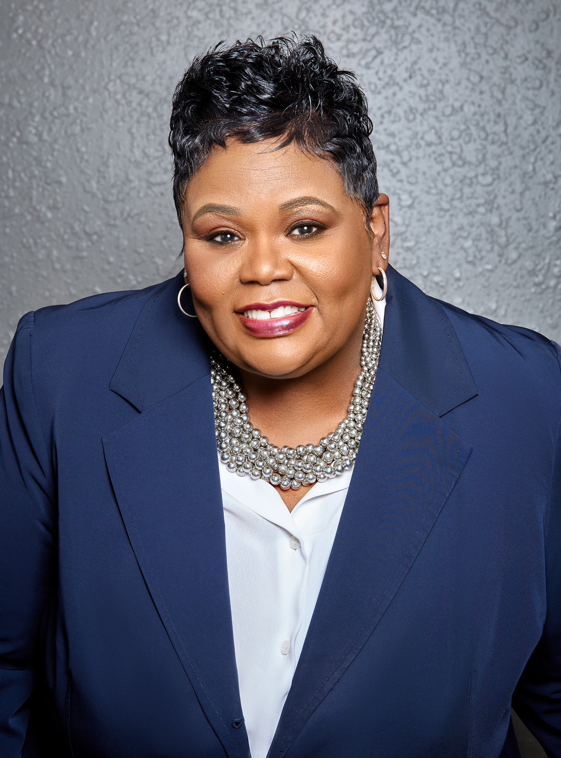 professional photo fo Angela M. Prince in a blue blazer and white blouse smiling for the camera